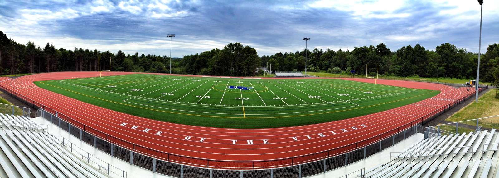 Aerial view of a freshly striped red running track surrounding a football field
